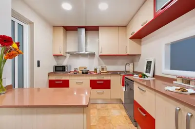 a kitchen with red cabinets and a vase of flowers at Lodging Apartments Villa de Gracia 2 bedroom cozy apartment in Barcelona