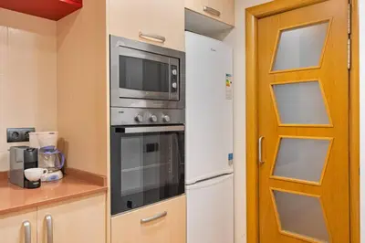 a kitchen with a microwave and a refrigerator at Lodging Apartments Villa de Gracia 2 bedroom cozy apartment in Barcelona