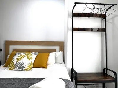 a bedroom with a bed with a black and yellow pillow at Barcelona COZY Apartment in Hospitalet de Llobregat