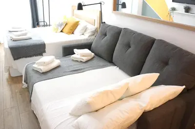 a living room with a couch and two beds at Barcelona COZY Apartment in Hospitalet de Llobregat
