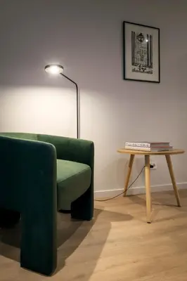 a living room with a green chair and a table at Mirador 1840 in Barcelona