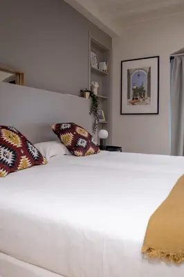 a white bed with two pillows on top of it at Mirador 1840 in Barcelona