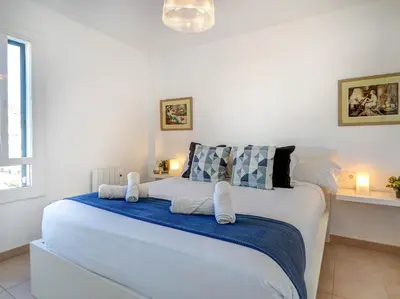 a bedroom with a large white bed with blue sheets at Balmins White by Hello Homes Sitges in Sitges