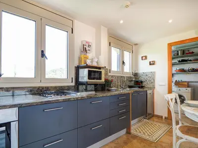 a kitchen with blue cabinets and a microwave at Los Condes Penthouse by Hello Homes Sitges in Sitges