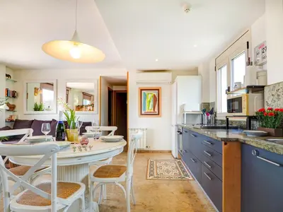 a kitchen and dining room with a table and chairs at Los Condes Penthouse by Hello Homes Sitges in Sitges