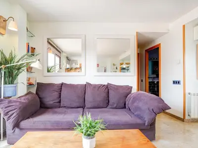 a purple couch in a living room with mirrors at Los Condes Penthouse by Hello Homes Sitges in Sitges