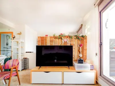 a living room with a tv and a fireplace at Los Condes Penthouse by Hello Homes Sitges in Sitges
