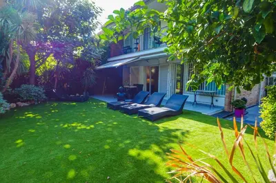 a backyard with a couch in the grass at Beach Apartment Garden Vinyet by Hello Homes Sitges in Sitges
