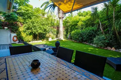 a patio with a table and chairs and a garden at Beach Apartment Garden Vinyet by Hello Homes Sitges in Sitges