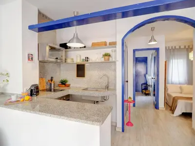 a kitchen with a sink and a room with a bed at Velero Attic by Hello Homes Sitges in Sitges