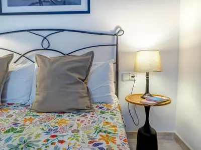 a bed with a pillow and a lamp on a table at Velero Attic by Hello Homes Sitges in Sitges