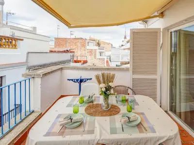 a table with a vase of flowers on a balcony at Velero Attic by Hello Homes Sitges in Sitges