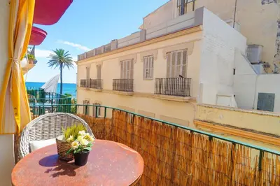 a table with flowers on top of a balcony at The Loft by Hello Homes Sitges in Sitges