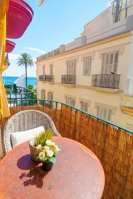 a table with a basket of flowers on a balcony at The Loft by Hello Homes Sitges in Sitges