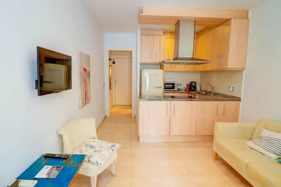 a kitchen and a living room with a couch and a table at The Loft by Hello Homes Sitges in Sitges