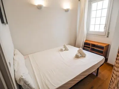 a small bedroom with a bed with towels on it at Barco Attic by Hello Homes Sitges in Sitges