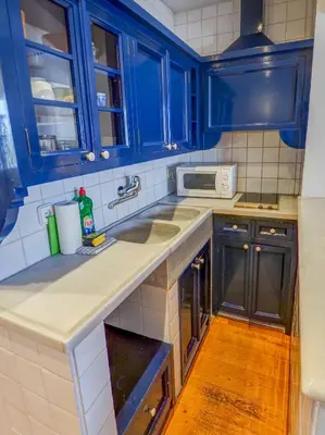 a kitchen with blue cabinets and a sink at Barco Attic by Hello Homes Sitges in Sitges