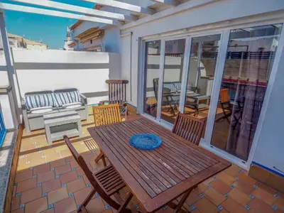 a deck with a wooden table and chairs on a patio at Barco Attic by Hello Homes Sitges in Sitges