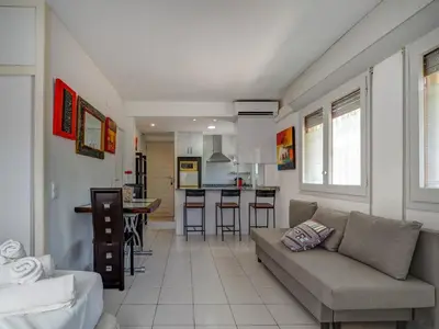 a living room with a couch and a kitchen at Los Globos Beach Studio by Hello Homes Sitges in Sitges