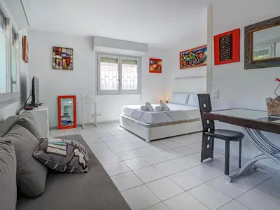 a bedroom with a bed and a table and a couch at Los Globos Beach Studio by Hello Homes Sitges in Sitges