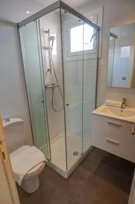 a bathroom with a shower and a toilet and a sink at Harbour terraces by Hello Homes Sitges in Sitges