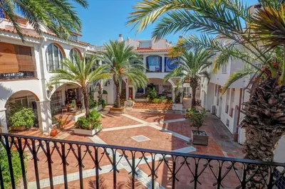 a view of the courtyard of a building with palm trees at Harbour terraces by Hello Homes Sitges in Sitges