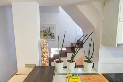 a dining room with three potted plants on a table at Harbour terraces by Hello Homes Sitges in Sitges