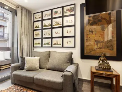 a living room with a couch and pictures on the wall at Click&Flat Luxury cabanyes in Barcelona