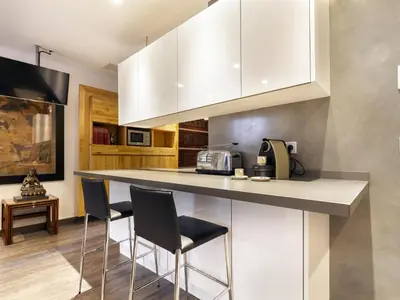 a kitchen with a counter with two stools at Click&Flat Luxury cabanyes in Barcelona