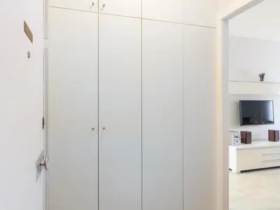 a row of white cabinets in a room with a tv at Click&Flat Xoriguer in Barcelona