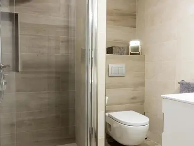 a bathroom with a toilet and a glass shower at Click&Flat Xoriguer in Barcelona