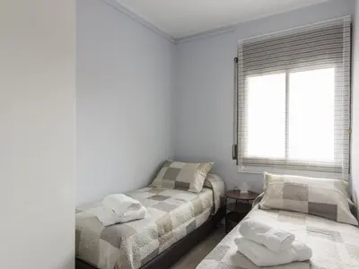 a bedroom with two beds and a window at Click&Flat Xoriguer in Barcelona