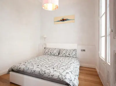 a white bedroom with a bed and a window at LUXURY BARCELONA CENTRAL CITY COSY 3 BEDROOM APARTMENT WITH PRIVATE TERRACE in Barcelona