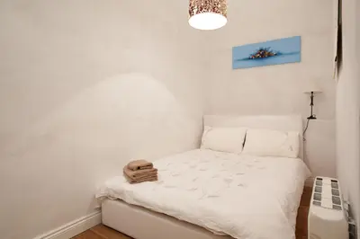 a small bedroom with a white bed and a light at LUXURY BARCELONA CENTRAL CITY COSY 3 BEDROOM APARTMENT WITH PRIVATE TERRACE in Barcelona