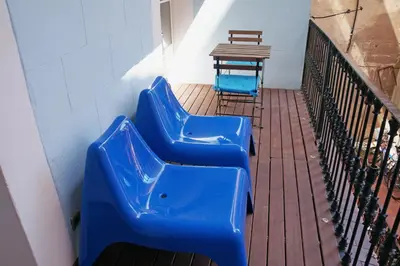 a row of blue benches sitting on a balcony at LUXURY BARCELONA CENTRAL CITY COSY 3 BEDROOM APARTMENT WITH PRIVATE TERRACE in Barcelona