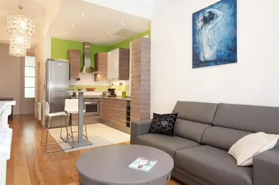 a living room with a couch and a kitchen at LUXURY BARCELONA CENTRAL CITY COSY 3 BEDROOM APARTMENT WITH PRIVATE TERRACE in Barcelona