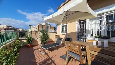 a patio with a wooden table and an umbrella at Opening Doors Sagrada Familia in Barcelona