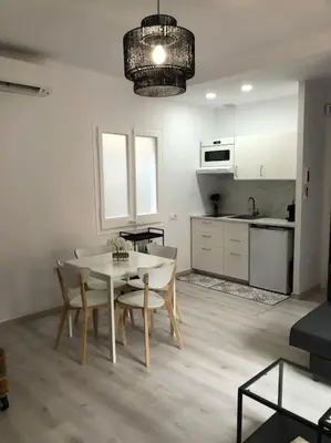 a kitchen and dining room with a table and chairs at Àtico lumineux à 10 min du centre ville in Hospitalet de Llobregat