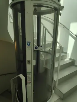 a glass elevator with stairs in a building at Apartment with a view close to the beach in Badalona