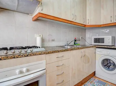 a kitchen with a sink and a washing machine at Sebastian Terrace Apartment by Hello Homes Sitges in Sitges