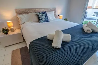 a bedroom with a large bed with towels on it at White Penthouse by Hello Homes Sitges in Sitges