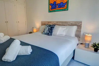 a bedroom with a large white bed with towels on it at White Penthouse by Hello Homes Sitges in Sitges
