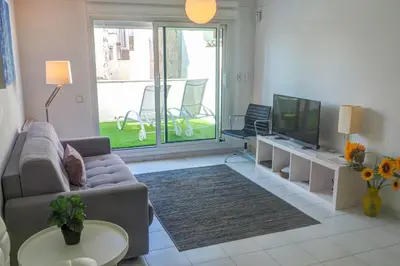 a living room with a couch and a tv at White Penthouse by Hello Homes Sitges in Sitges