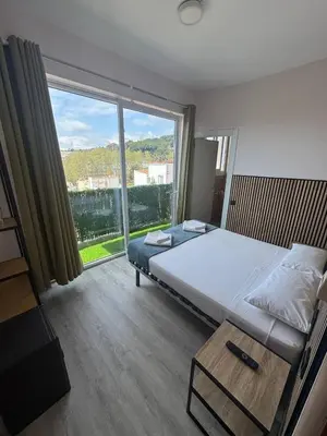 a bedroom with a bed and a large window at COLIBRI in Calella