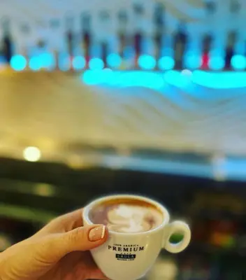 a hand holding a cup of coffee with a view at COLIBRI in Calella