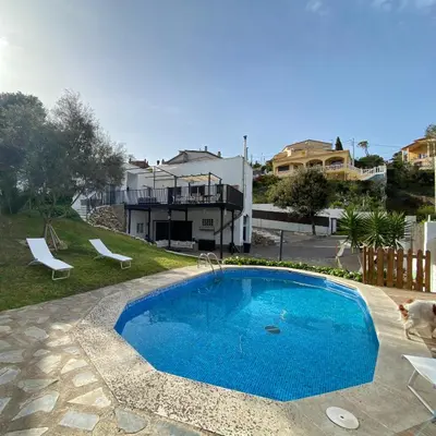 a cat is sitting next to a swimming pool at Villa Maioli in Olivella