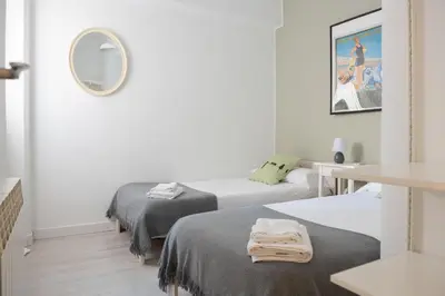 a white room with two beds and a mirror at Seneca7 near paseo de gracia in Barcelona