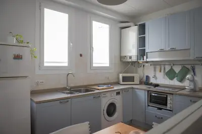 a kitchen with white cabinets and a washing machine at Seneca7 near paseo de gracia in Barcelona