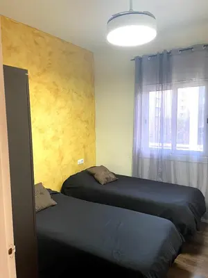 two beds in a bedroom with a window at APARTAMENTO BARCELONA in Barcelona