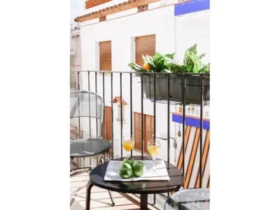 a balcony with a table and two glasses of wine at Sitges Spaces Deluxe Beach Apartment- 3 Bedroom, 2 Bathroom, Next to Beach, Sleeps 6 in Sitges